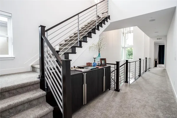 a view of a hallway with wooden floor and stairs