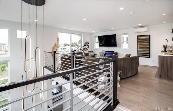 a living room with furniture flat screen tv and windows