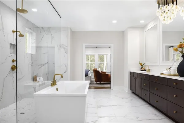 a spacious bathroom with a tub sink and mirror
