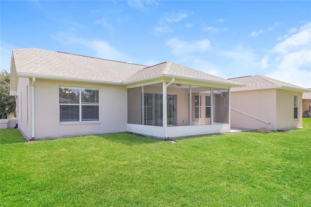 8358 Natoma Street Spring Hill, FL 34606 - Photo 15 of 16 a view of a house with a yard and a large tree