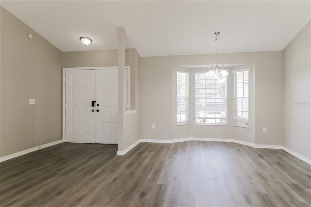 8358 Natoma Street Spring Hill, FL 34606 - Photo 3 of 16 a view of an empty room with wooden floor and a window