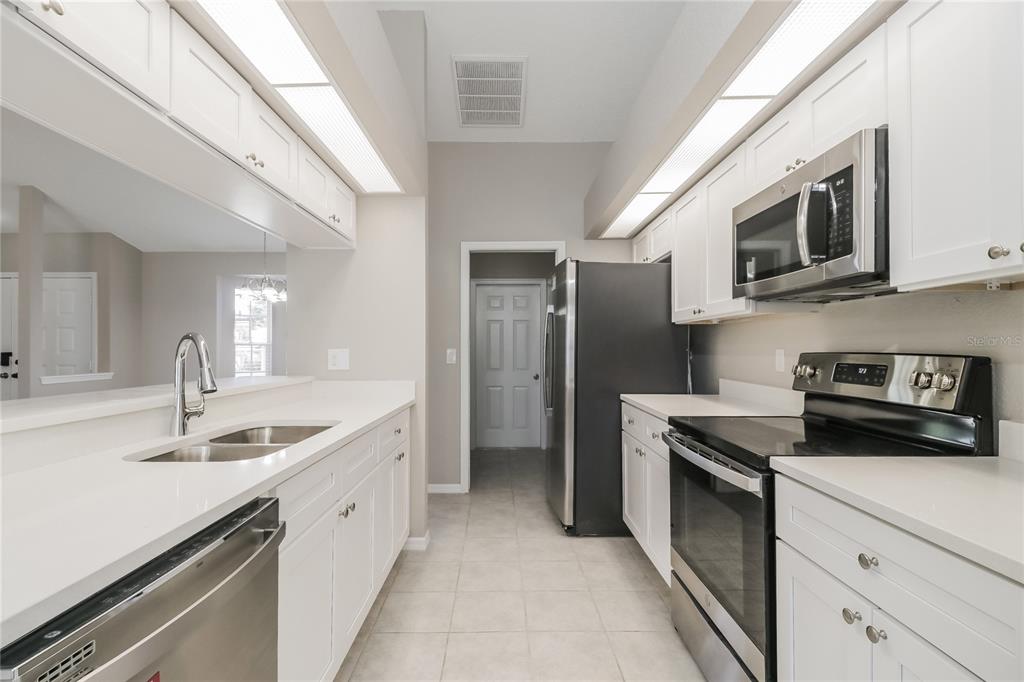 8358 Natoma Street Spring Hill, FL 34606 - Photo 6 of 16 a kitchen with stainless steel appliances granite countertop a sink and a stove