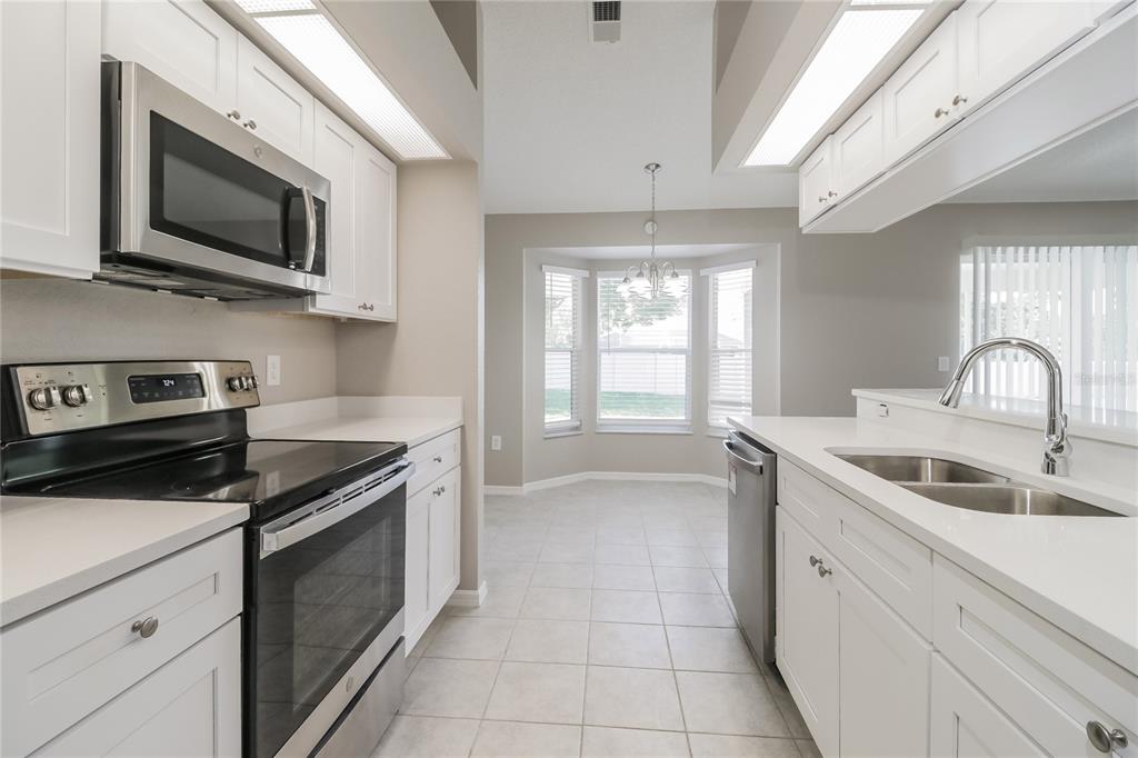 8358 Natoma Street Spring Hill, FL 34606 - Photo 7 of 16 a kitchen with a sink stove and microwave