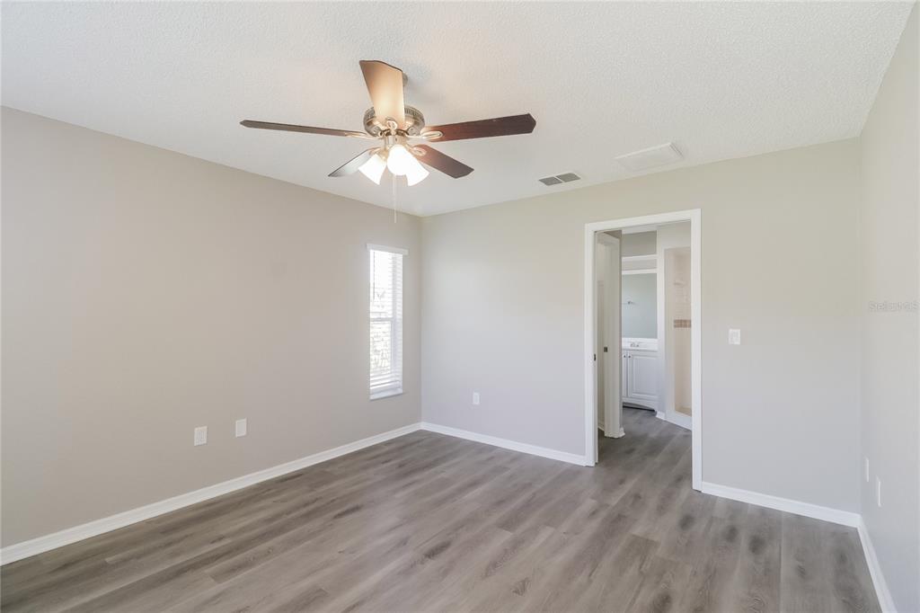 8358 Natoma Street Spring Hill, FL 34606 - Photo 8 of 16 an empty room with wooden floor fan and windows