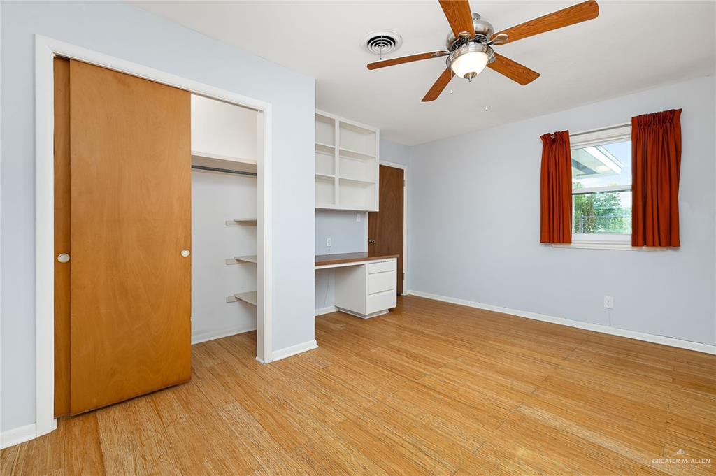 1001 West 7th Street Weslaco, TX 78596 - Photo 13 of 24 a view of empty room with wooden floor and fan