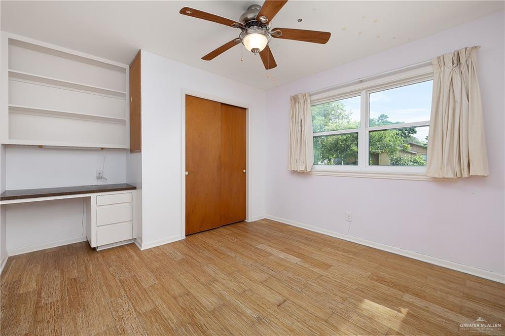 1001 West 7th Street Weslaco, TX 78596 - Photo 9 of 24 a view of an empty room with a window and a ceiling fan
