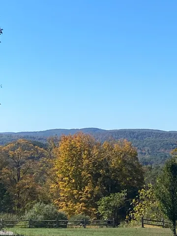 an aerial view of house with yard and mountain view in back