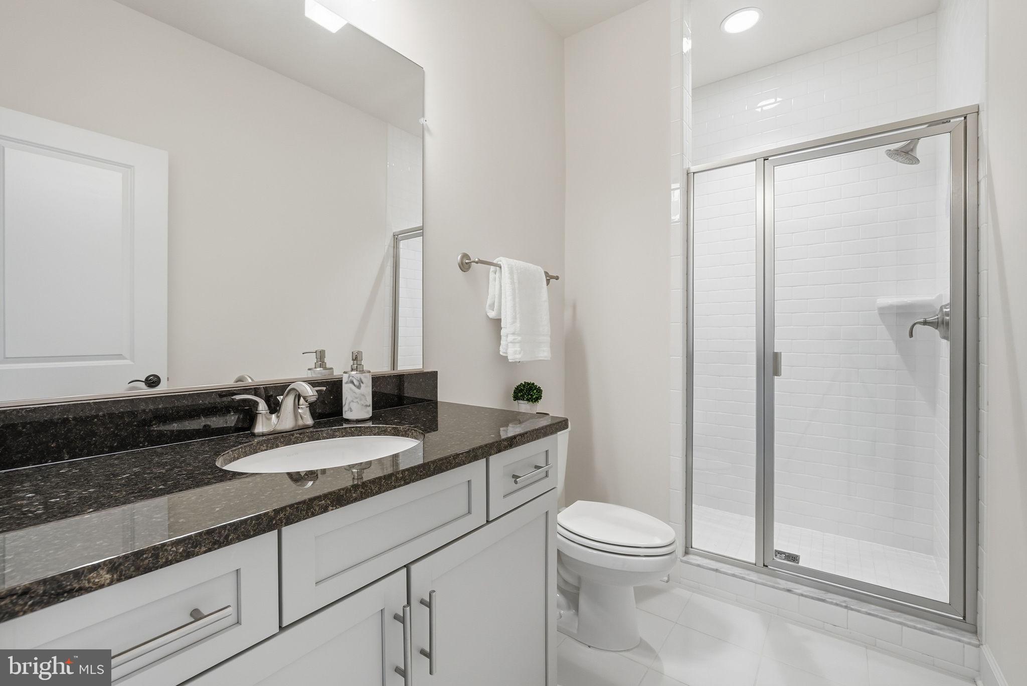 2867 Hill Road Vienna, VA 22181 - Photo 50 of 70 a bathroom with a granite countertop sink toilet a mirror and shower