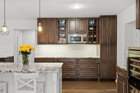 a kitchen with stainless steel appliances kitchen island granite countertop a refrigerator and cabinets