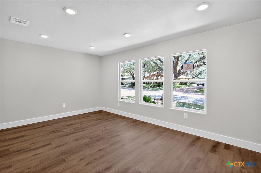 601 West Zenith Avenue Temple, TX 76501 - Photo 13 of 25 an empty room with wooden floor and windows