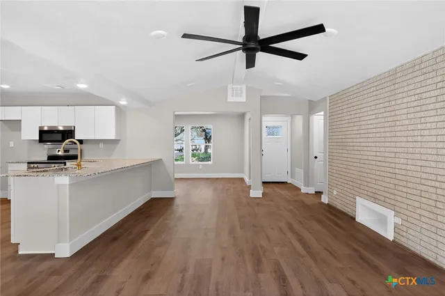 a view of a kitchen with a sink and dishwasher a refrigerator with wooden floor