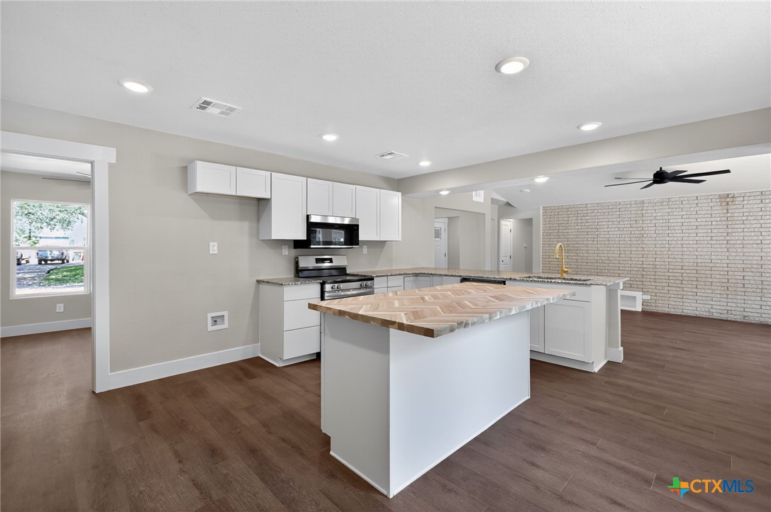 601 West Zenith Avenue Temple, TX 76501 - Photo 4 of 25 a large kitchen with kitchen island wooden cabinets and stainless steel appliances