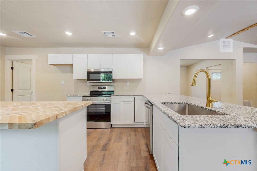 601 West Zenith Avenue Temple, TX 76501 - Photo 5 of 25 a kitchen with granite countertop a sink stove and refrigerator