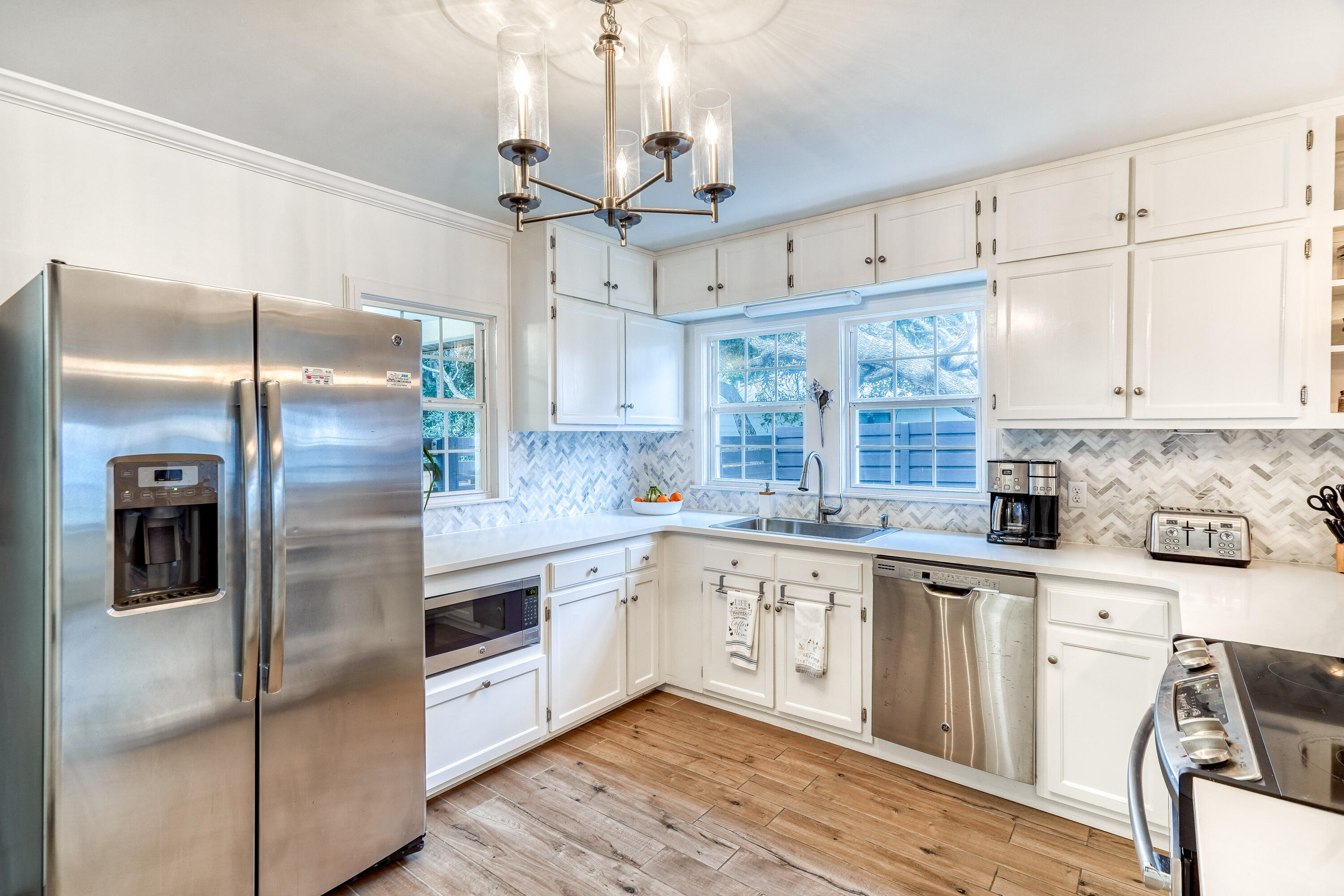 2912 East County Highway 30A Santa Rosa Beach, FL 32459 - Photo 2 of 43 a modern kitchen with stainless steel appliances granite countertop a refrigerator a sink and white cabinets