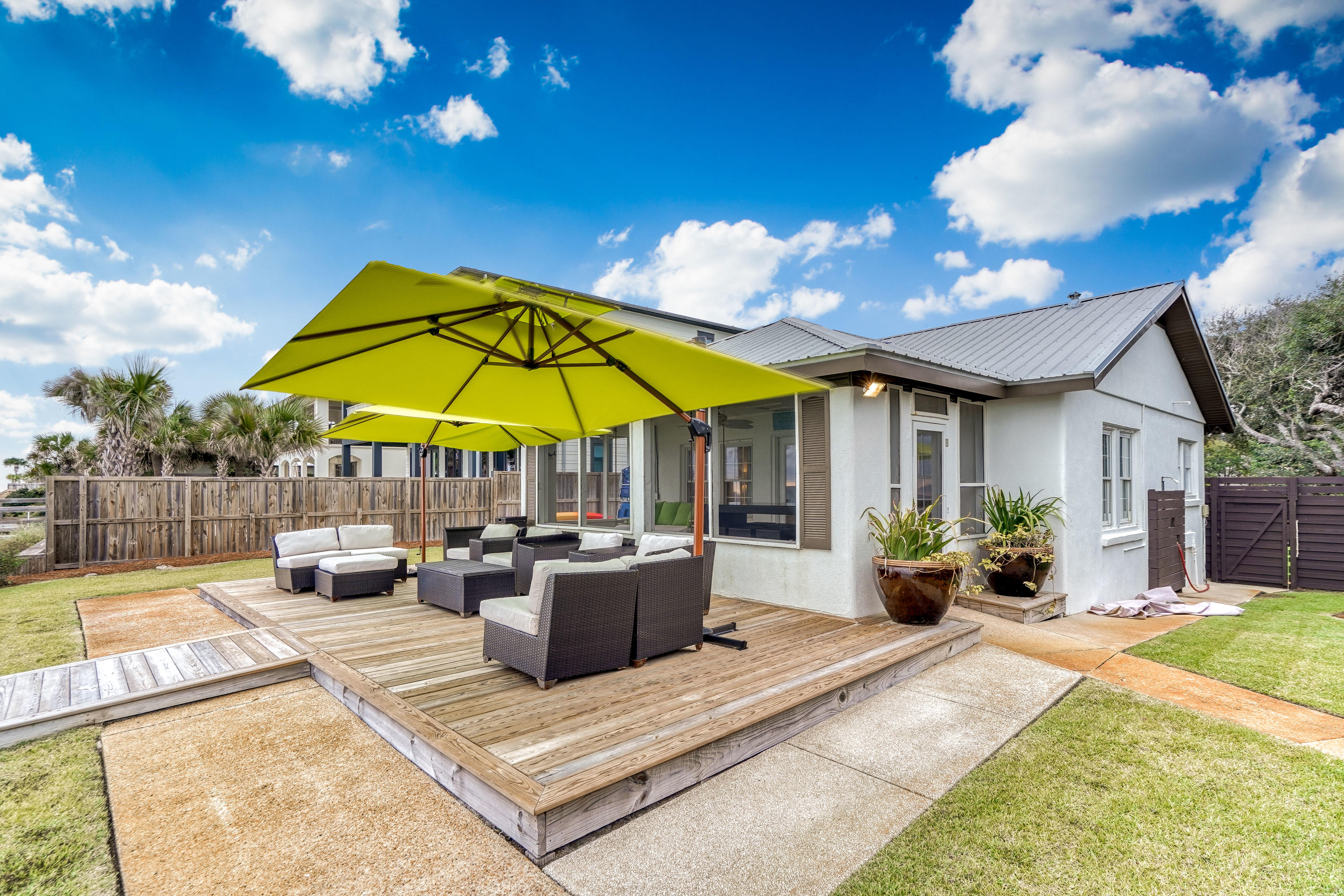 2912 East County Highway 30A Santa Rosa Beach, FL 32459 - Photo 34 of 43 a view of a patio with couches table and chairs under an umbrella