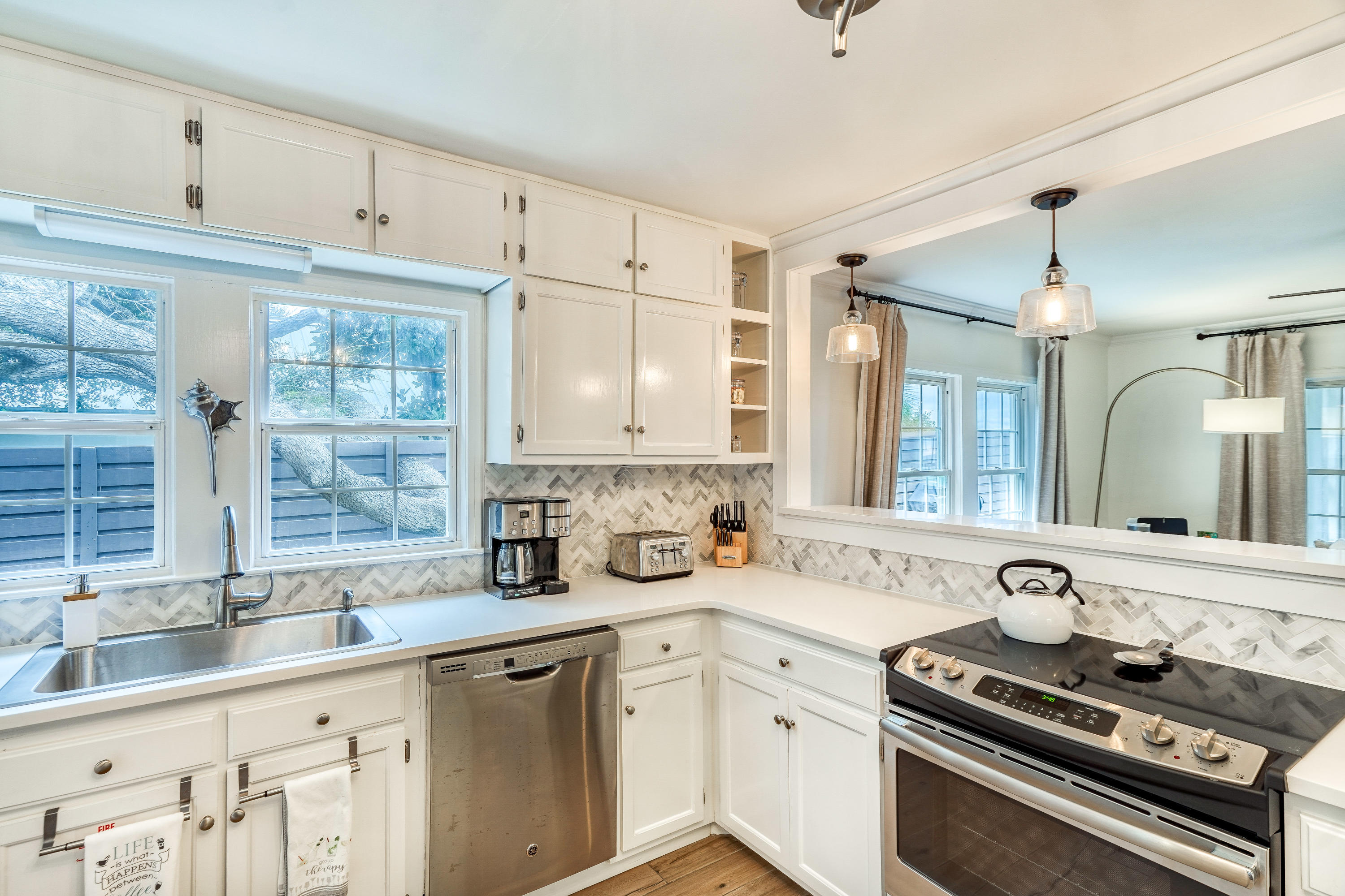 2912 East County Highway 30A Santa Rosa Beach, FL 32459 - Photo 7 of 43 a kitchen with stainless steel appliances a sink stove and cabinets