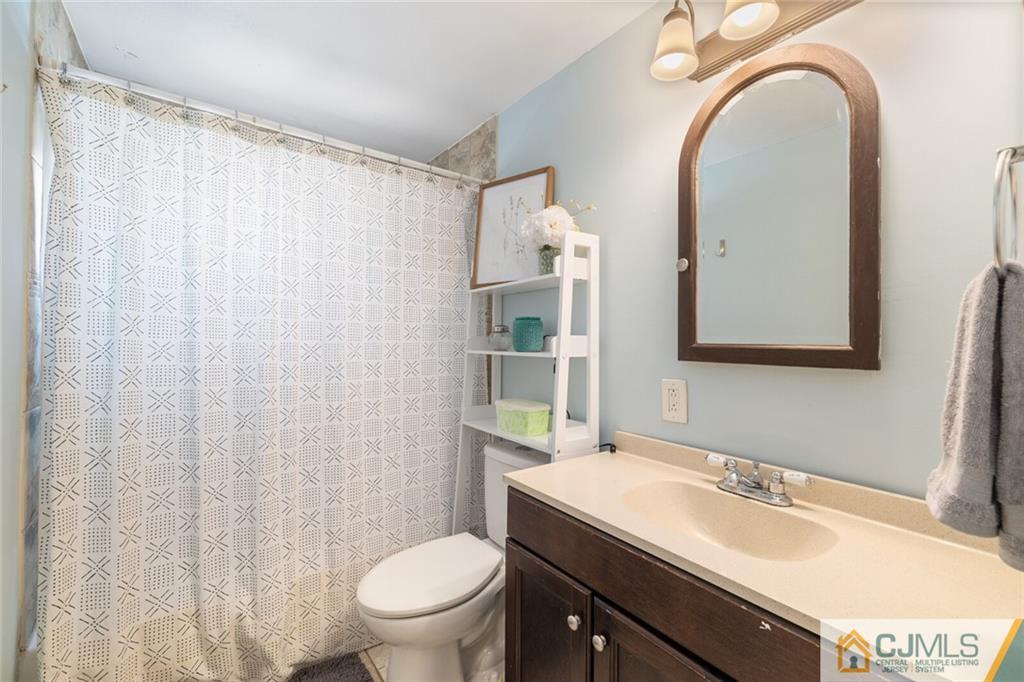 65 Albemarle Road Colonia, NJ 07067 - Photo 16 of 28 a bathroom with a granite countertop sink a toilet and a mirror