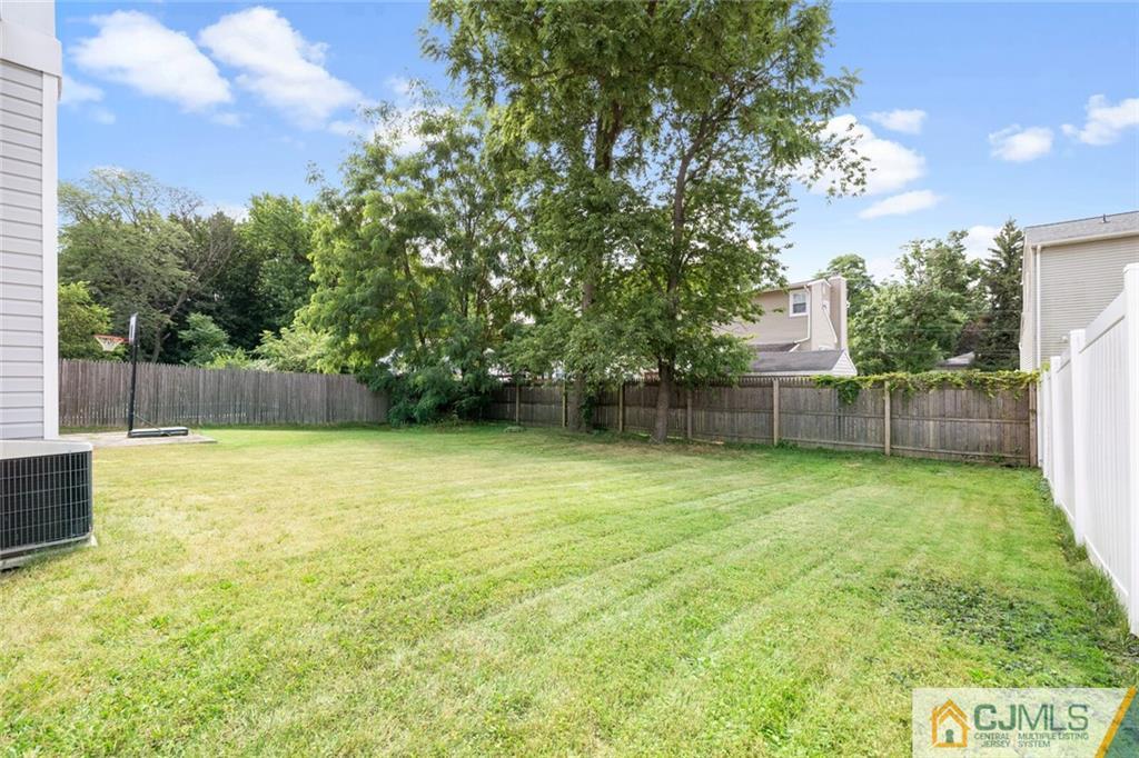 65 Albemarle Road Colonia, NJ 07067 - Photo 23 of 28 a view of a backyard with a tree and wooden fence