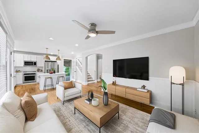 a dining room with stainless steel appliances kitchen island granite countertop a refrigerator a stove a microwave oven a dining table and chairs with wooden floor