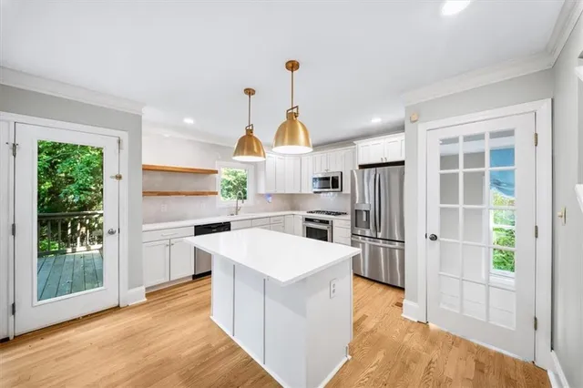a kitchen with cabinets stainless steel appliances and wooden floor