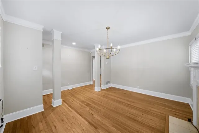 an empty room with wooden floor and a ceiling fan