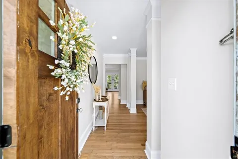 a view of a hallway with wooden floor and staircase