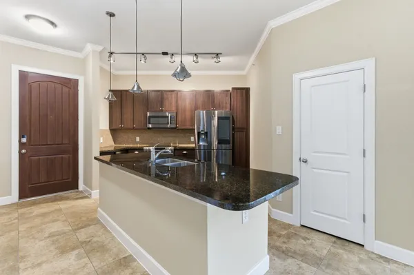 a kitchen with stainless steel appliances granite countertop a sink a stove and a refrigerator