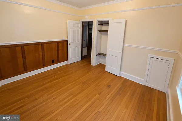 an empty room with wooden floor and entrance