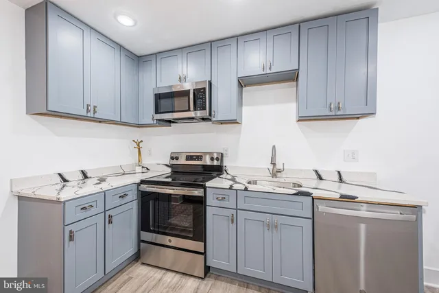 a kitchen with stainless steel appliances granite countertop a sink stove a microwave and cabinets