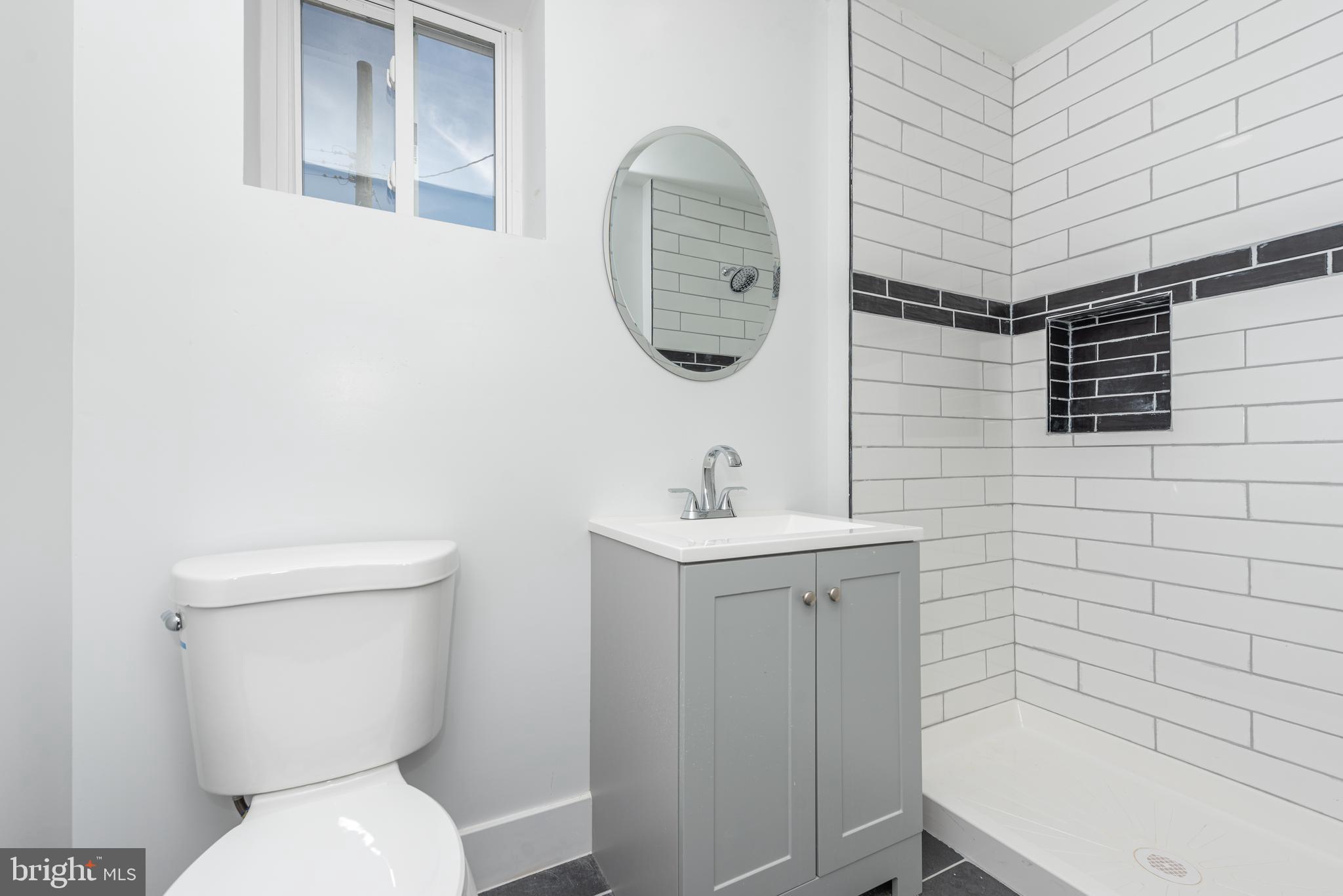 1007 North Mount Street Baltimore, MD 21217 - Photo 7 of 22 a bathroom with a toilet a sink and mirror