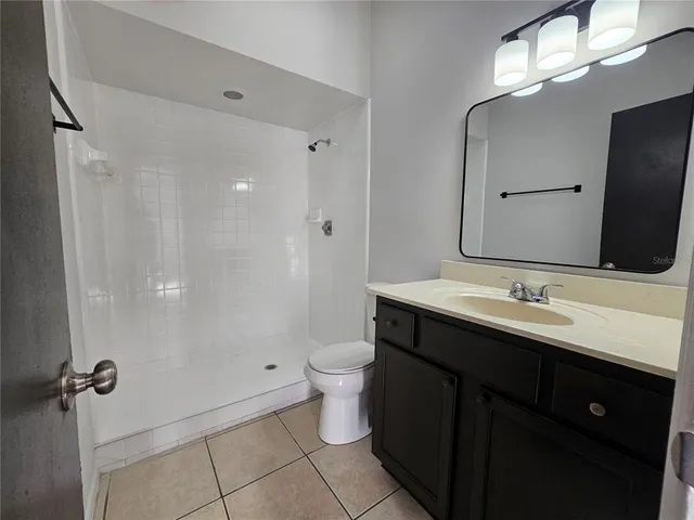 a bathroom with a double vanity sink toilet and a mirror