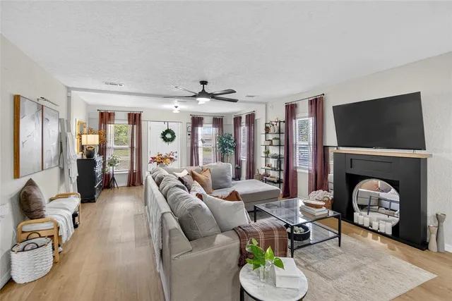 a living room with furniture a flat screen tv and a fireplace