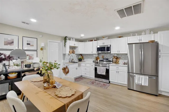 a kitchen with refrigerator cabinets dining table and chairs