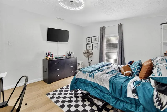 a bedroom with bed and a chandelier