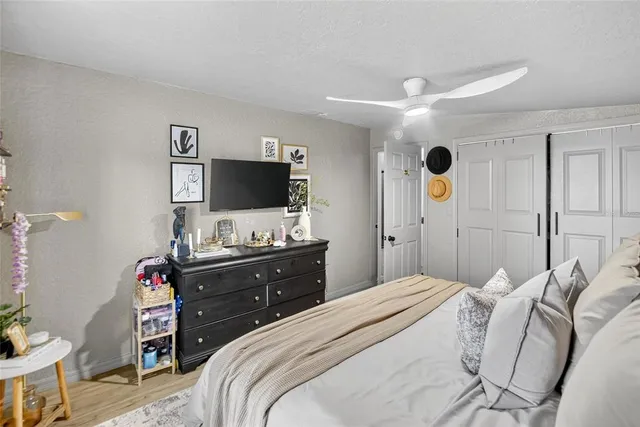 a bedroom with a bed and a flat tv screen on dresser