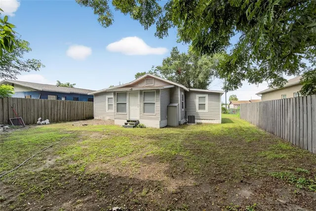 a backyard of a house with trees and wooden fence