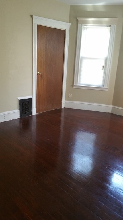 35 Kenberma Road Boston, MA 02124 - Photo 5 of 17 an empty room with wooden floor and windows
