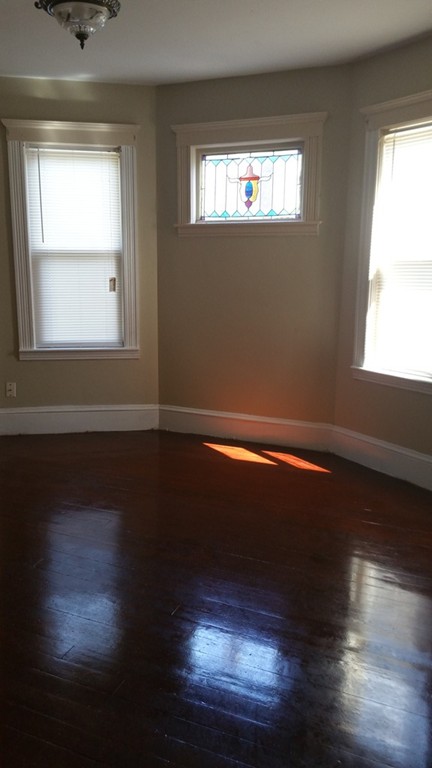 35 Kenberma Road Boston, MA 02124 - Photo 6 of 17 a view of empty room with wooden floor and fan
