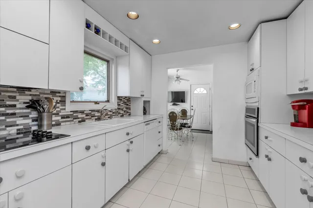a room with white cabinets and window
