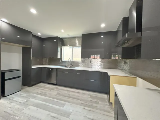 a large kitchen with granite countertop a large counter top stainless steel appliances and cabinets