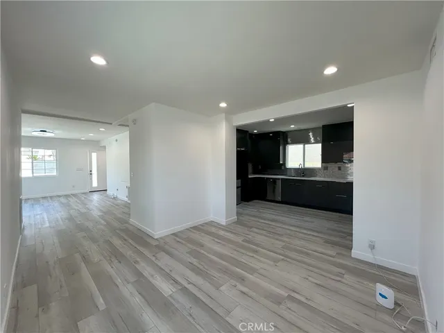 wooden floor in an empty room with a kitchen