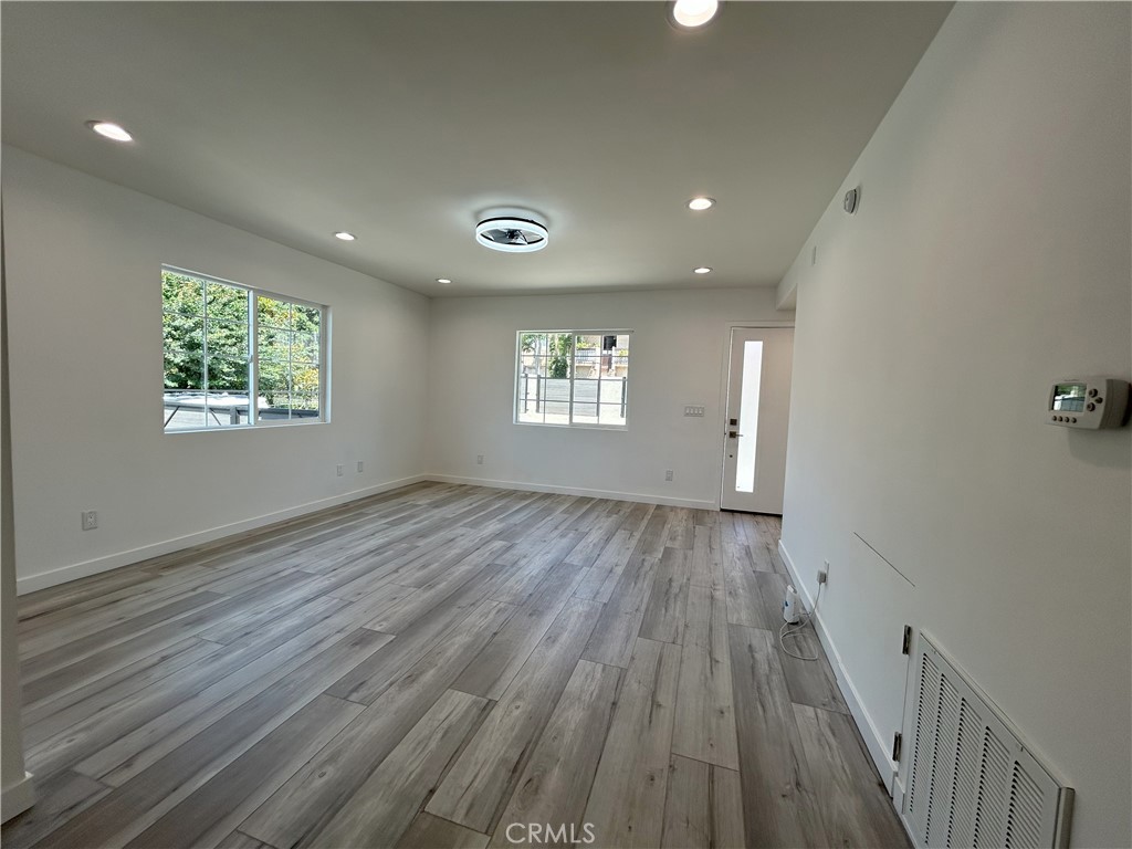 10363 Commerce Avenue Tujunga, CA 91042 - Photo 20 of 31 an empty room with wooden floor and windows