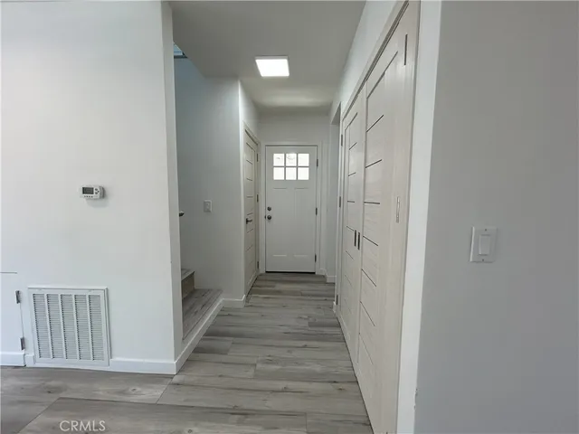 a view of a hallway with wooden floor and a hallway