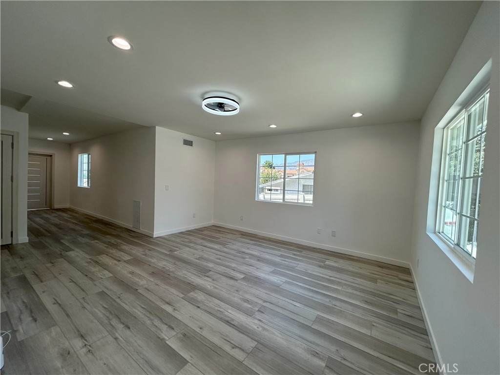 10363 Commerce Avenue Tujunga, CA 91042 - Photo 24 of 31 an empty room with wooden floor and windows