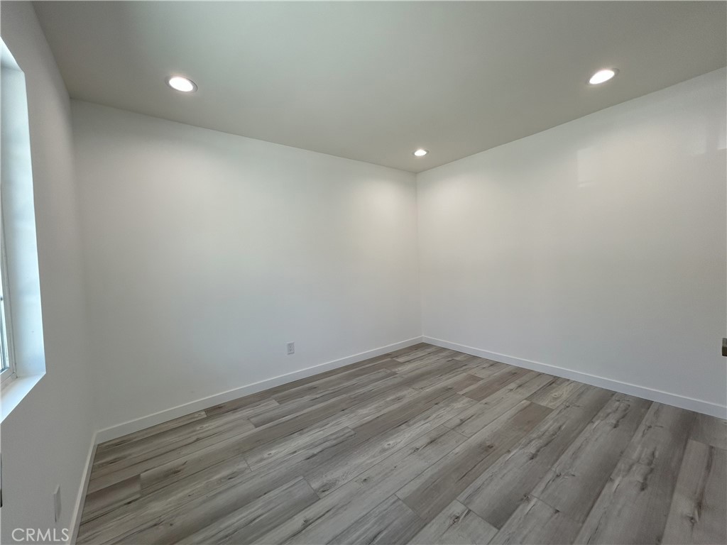 10363 Commerce Avenue Tujunga, CA 91042 - Photo 26 of 31 an empty room with wooden floor and windows