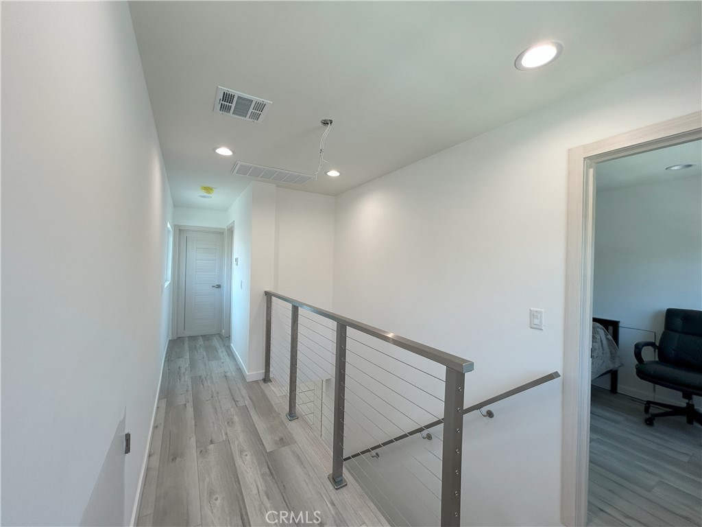 10363 Commerce Avenue Tujunga, CA 91042 - Photo 6 of 31 a view of a hallway with wooden floor and furniture
