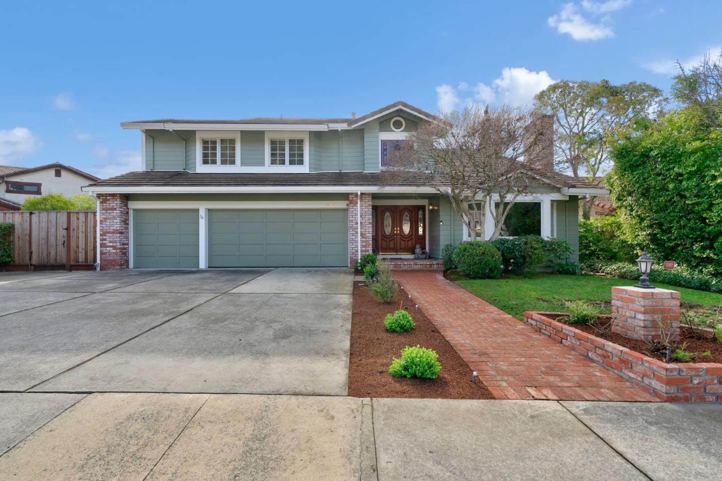 a front view of a house with a garden and mountain view