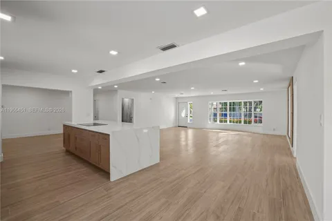 a spacious bedroom with a bed and a painting on the wall