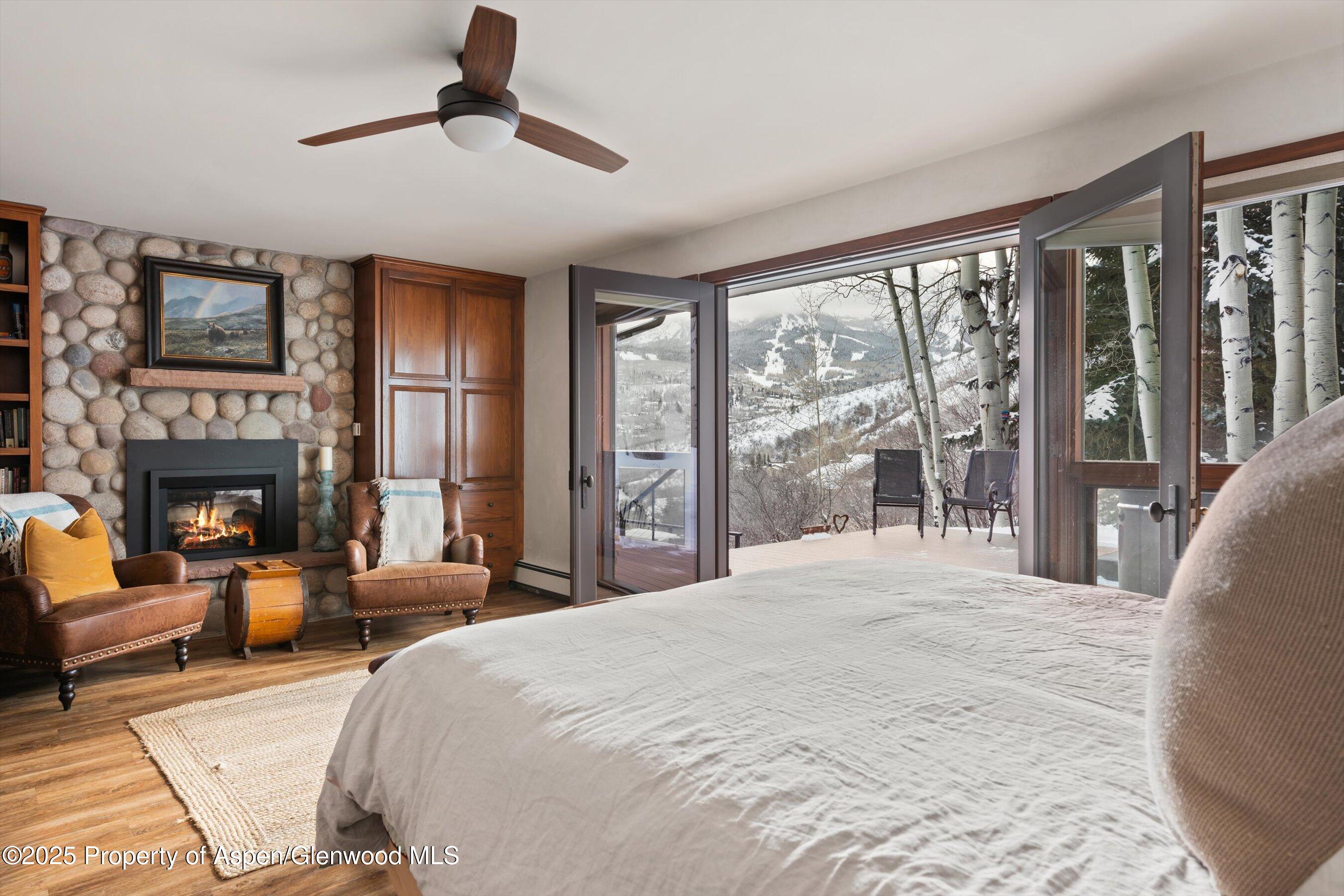 516 Sinclair Road Snowmass Village, CO 81615 - Photo 28 of 37 a bedroom with a large bed and a fireplace