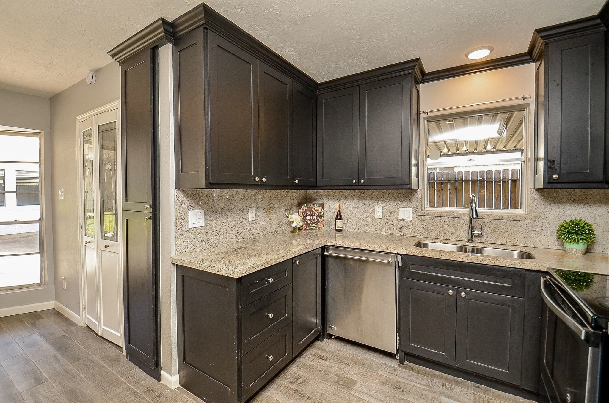 9215 Sharpcrest Street Houston, TX 77036 - Photo 11 of 31 a kitchen with a sink a stove and cabinets